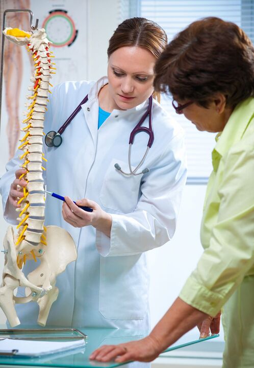 lékař prokazuje osteochondrózu páteře na maketě
